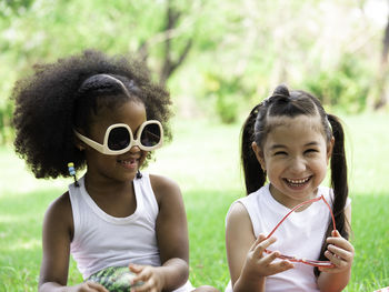 Two little lovely girls of various ethnic having fun in park on summer day.