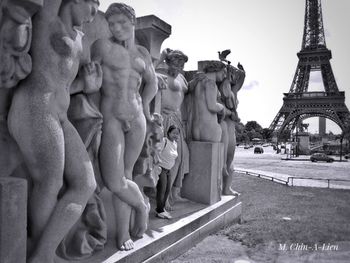 Statue of statues in city against sky