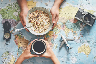 High angle view of woman holding coffee cup on table