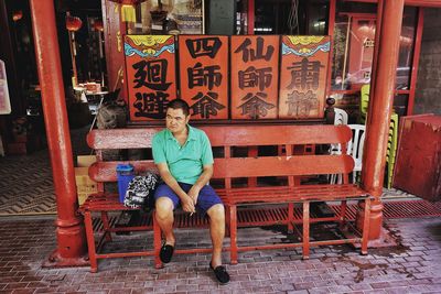 Full length of woman sitting on bench