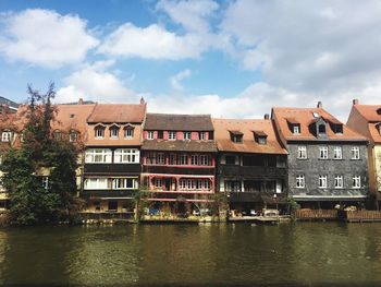 Buildings in city against cloudy sky