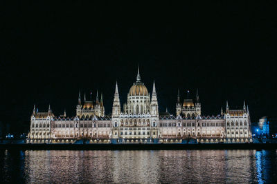 River with illuminated buildings in background at night