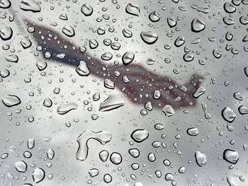 American flag seen through wet glass window during rainy season