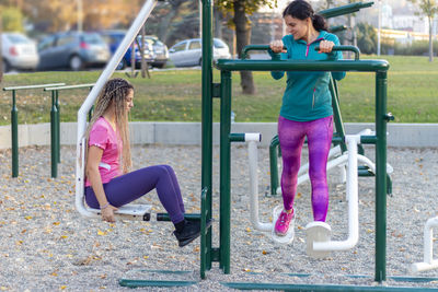 Mother and daughter are working out at the outside gym and having healthy and active lifestyle 
