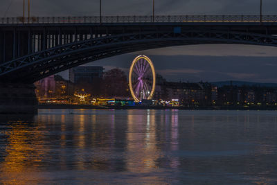 Illuminated ferris wheel in city at night