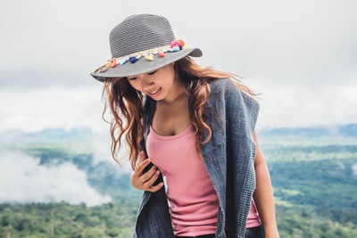 Young woman wearing hat while standing on land