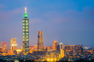 Illuminated buildings in city against sky