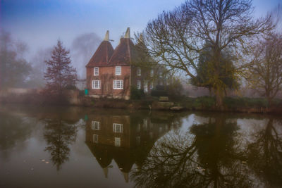 Building by lake against sky