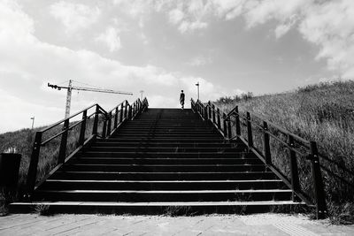 Low angle view of person on steps against sky