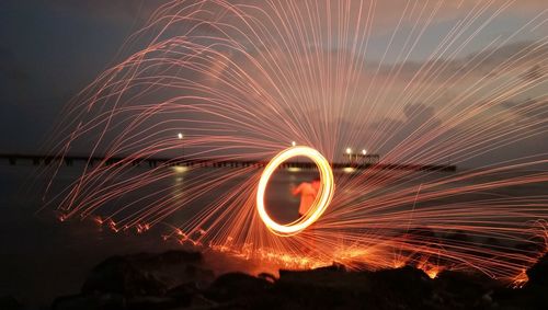 Wire wool at beach against sky