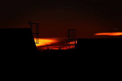 Silhouette fence against orange sky