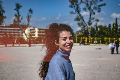 Portrait of young woman standing on road