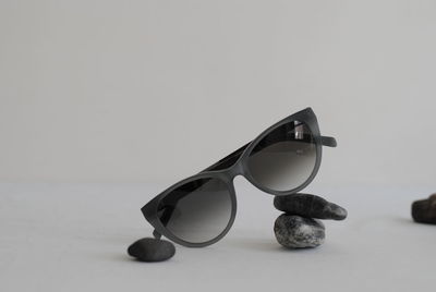 Close-up of sunglasses on table against white background