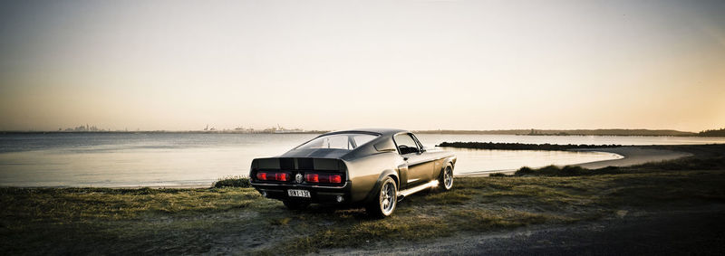 Vintage car on beach against clear sky