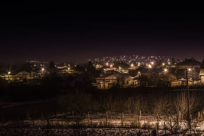 Illuminated cityscape against sky at night