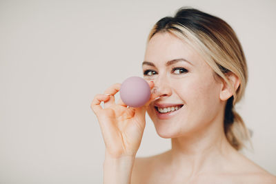 Portrait of smiling young woman over white background