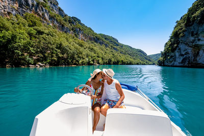 Woman on boat in sea against blue sky