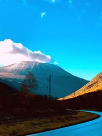 Scenic view of snowcapped mountains against blue sky