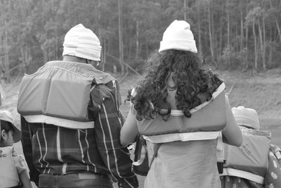 Rear view of people walking in snow