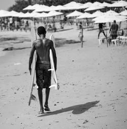 Rear view of man walking on beach