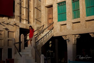 Full length of man standing by building in city