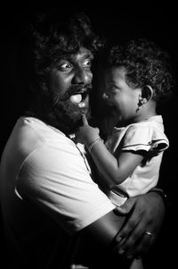 Close-up of father with daughter standing in darkroom