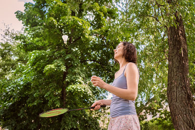 Low angle view of woman standing against plants