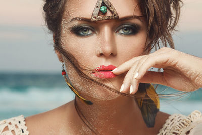 Close-up portrait of beautiful woman with sand on face
