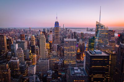 Aerial view of buildings in city at sunset