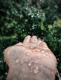 Close-up of water splashing on man