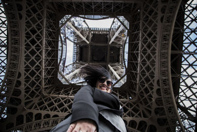 Directly below view of woman standing under eiffel tower