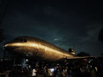 People at airport against sky at night