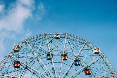 Low angle view of ferris wheel against blue sky