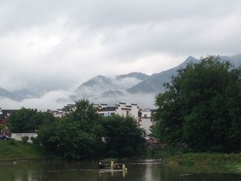 Scenic view of river and mountains against cloudy sky
