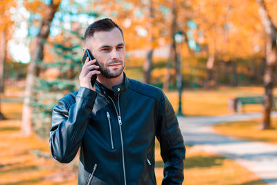 Young man using mobile phone outdoors