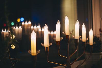 Close-up of lit candles in temple against building