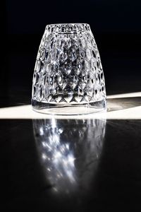 Close-up of clock on glass table against black background