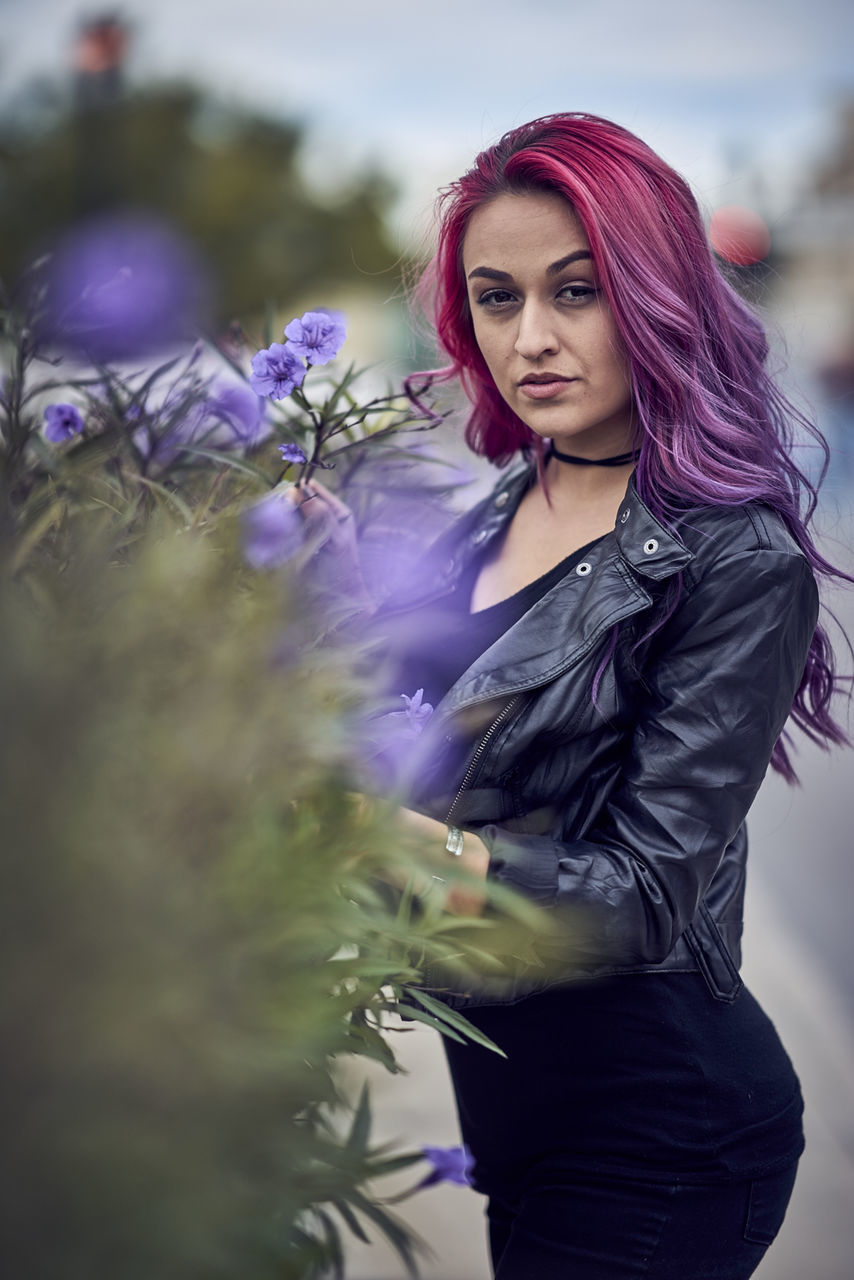 PORTRAIT OF BEAUTIFUL YOUNG WOMAN STANDING AGAINST WHITE