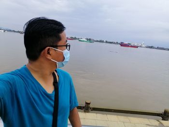 Portrait of young man against sea against sky