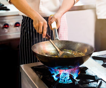 Midsection of man preparing food in kitchen