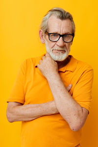 Portrait of senior man against yellow background
