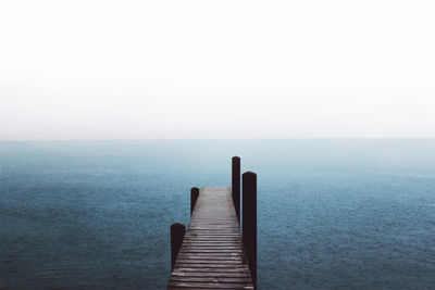 Pier over sea against clear sky