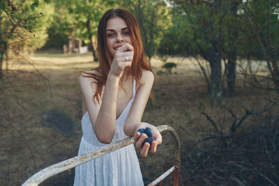 Portrait of young woman sitting on tree