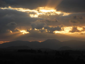 Scenic view of silhouette mountains against dramatic sky