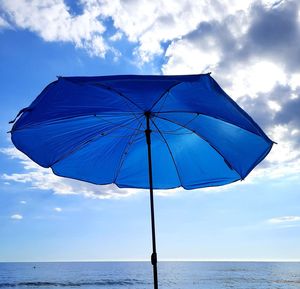 Umbrella on beach against sky