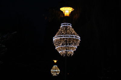 Low angle view of illuminated city against sky at night