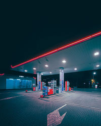 Illuminated empty road against sky at night