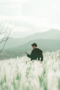 Rear view of man on field against sky