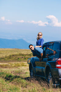 Men sitting on land against sky