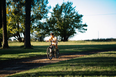 Boy riding bicycle on road at park